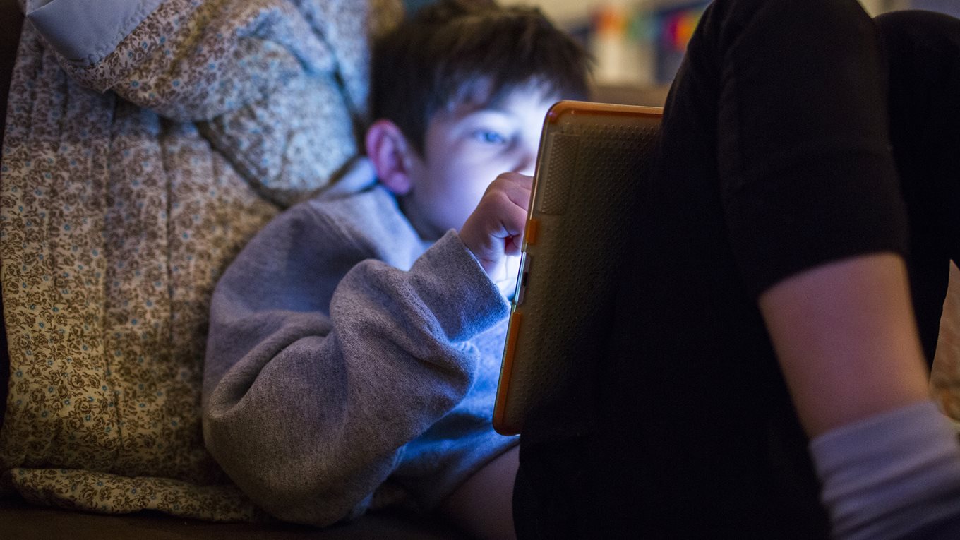 A boy on a sofa with a tablet