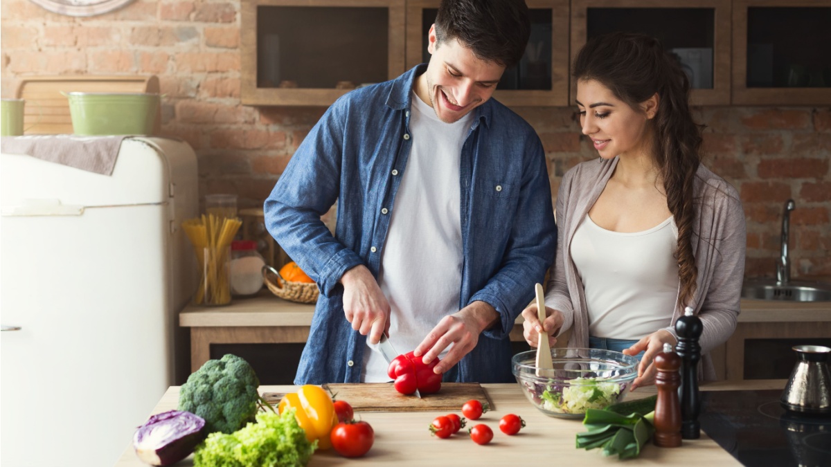 A healthy vegetarian couple prepare a meal