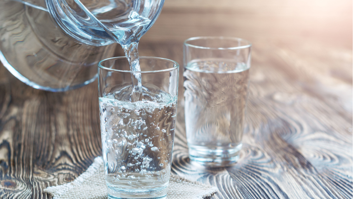 Jug of water with chopped lemon and mint leaves
