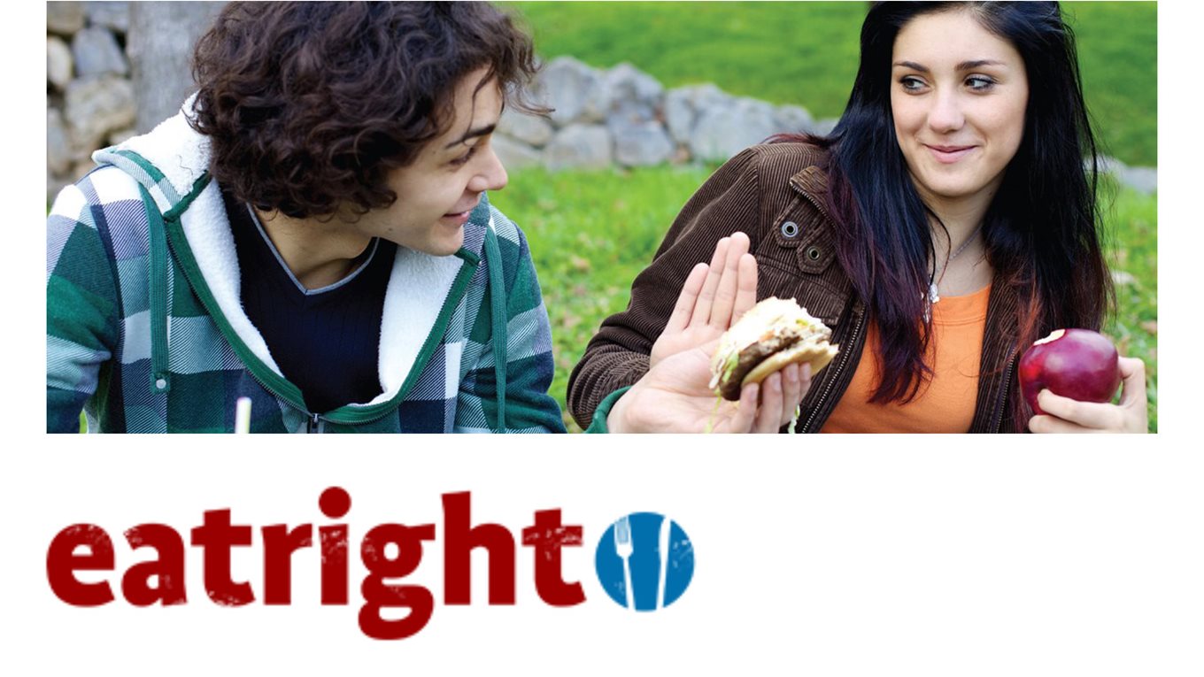 Teenage boy and girl with healthy and unhealthy food