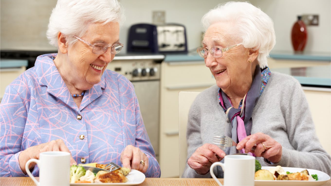 Two older women enjoying a meal together