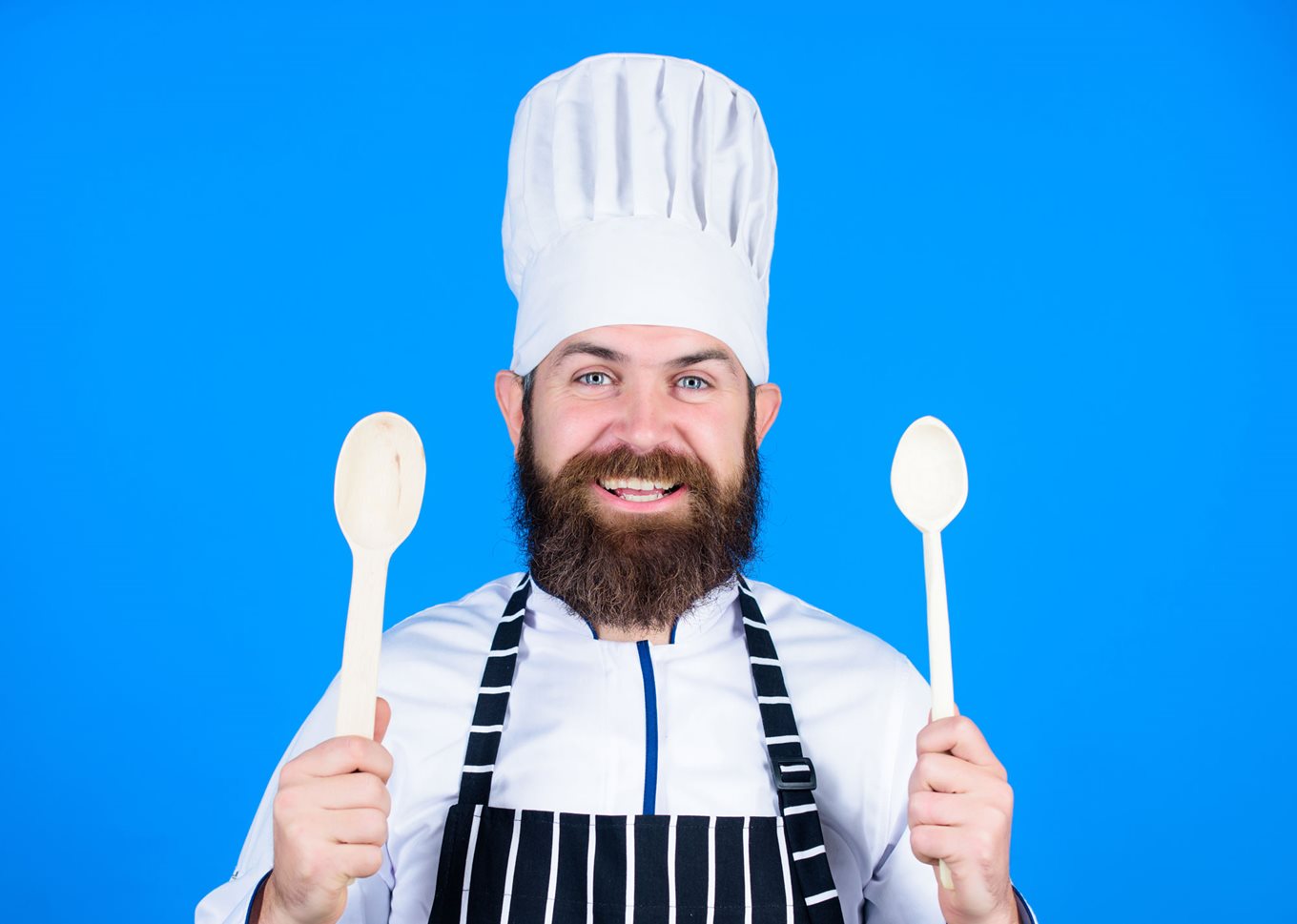 Chef holding two wooden spoons