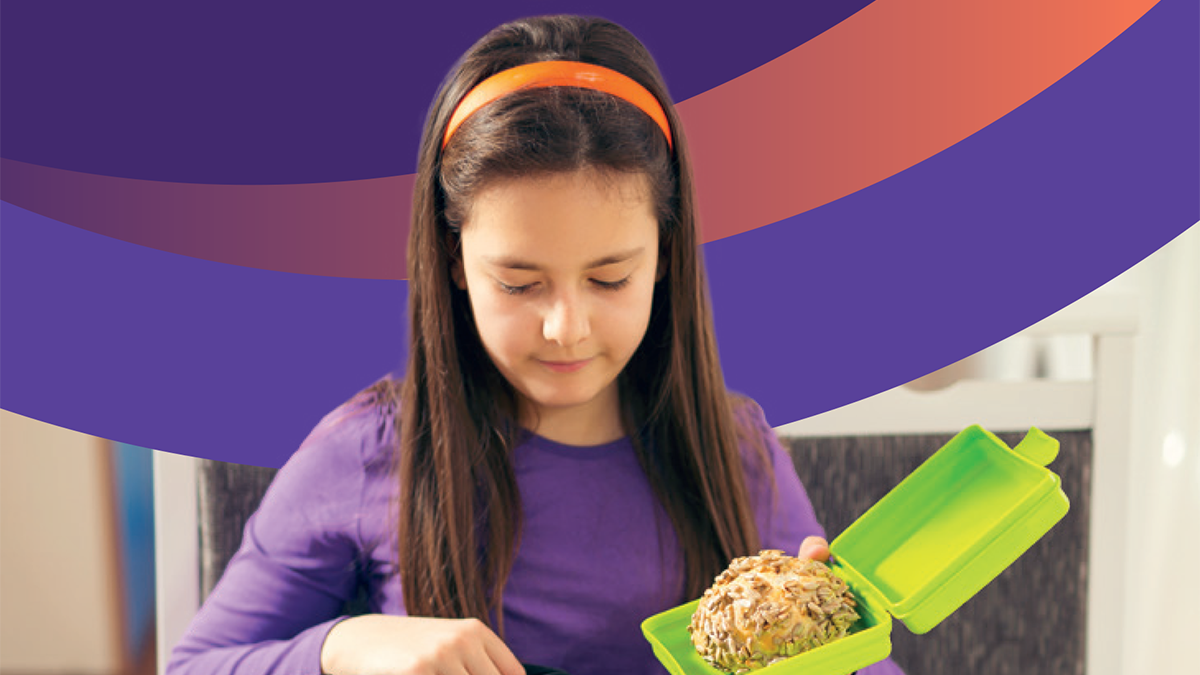Schoolgirl putting lunchbox into schoolbag