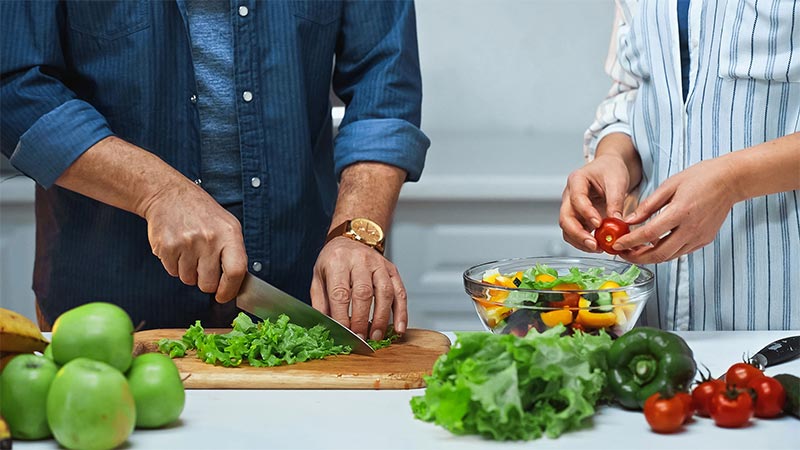 Knife and chopping board being used to prepare food in normal lighting