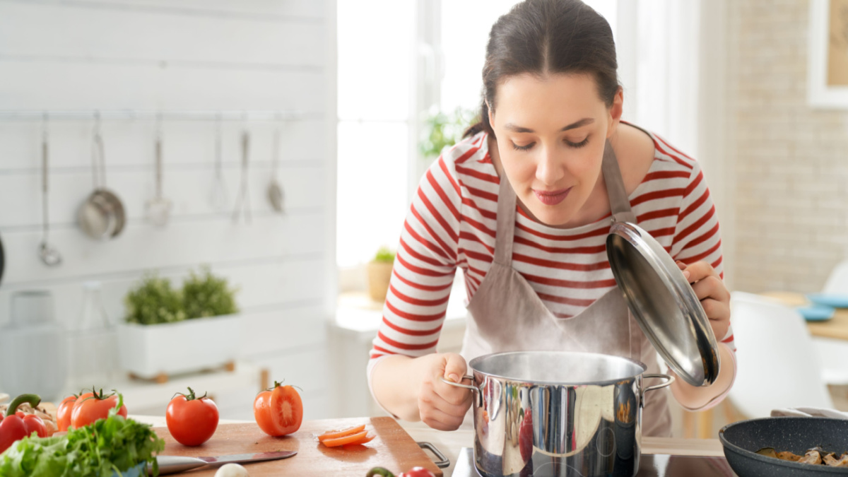 Woman looking at food in a cooking pot